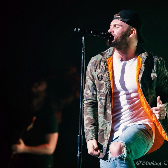 Dylan Scott dancing and singing into the microphone.
